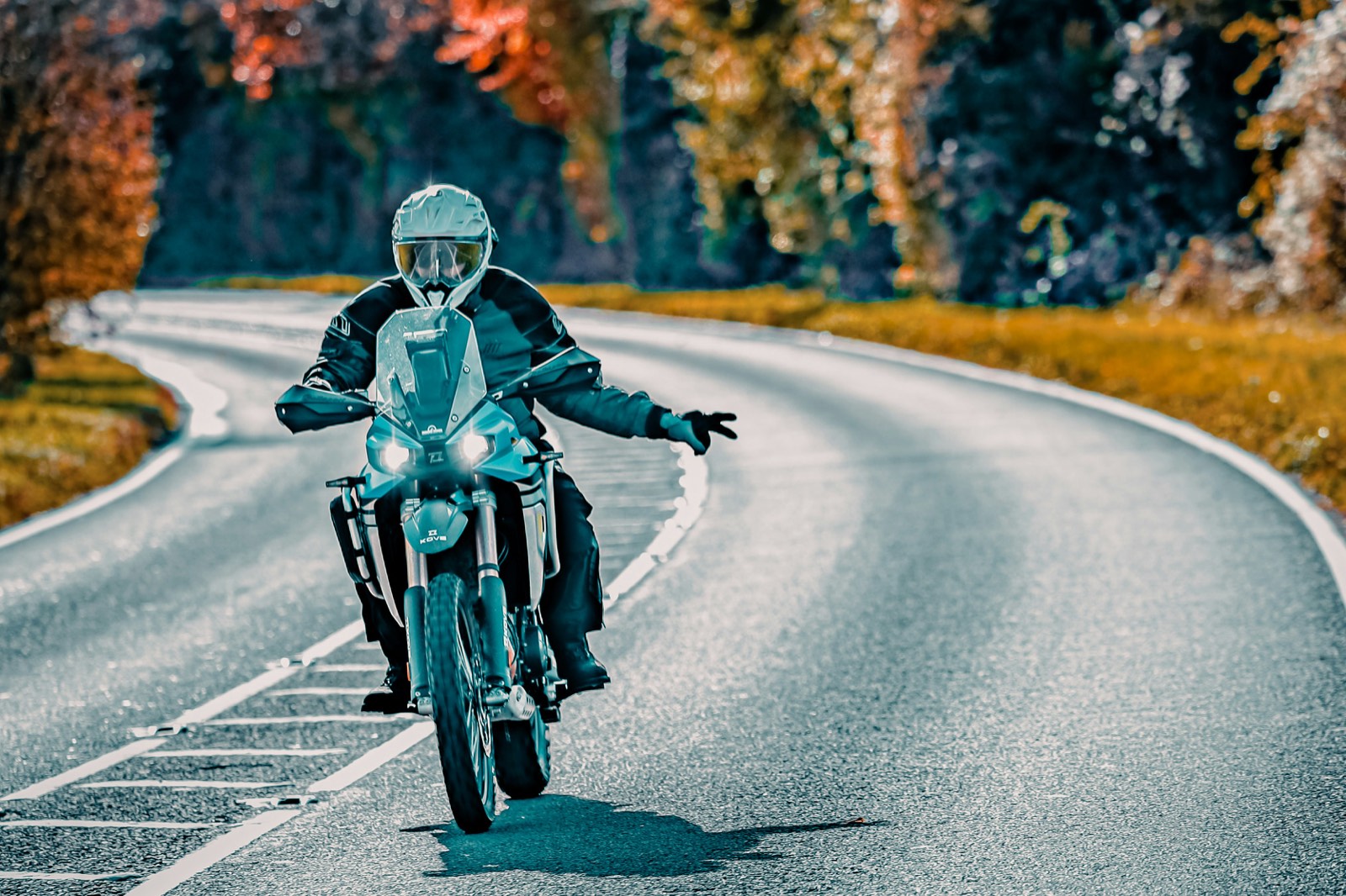 Rider carving an autumn mountain road